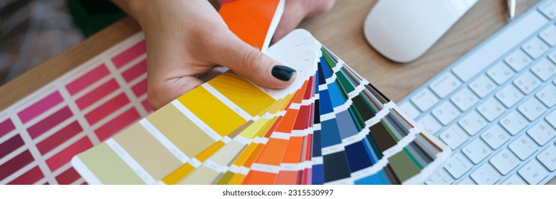Top view of woman designer holding fan of colourful samples in hand. Designer searching proper colour for promotion. Design and art concept - Shutterstock ID 2315530997