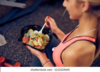 Top view of woman eating healthy food while sitting in a gym. Heatlhy lifestyle concept.