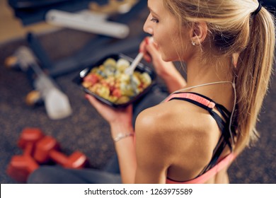 Top View Of Woman Eating Healthy Food While Sitting In A Gym. Healthy Lifestyle Concept.