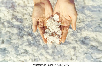 Top View Woman Hands Holding Crystallized Salt Natural Mineral Formation At Dead Sea Coastline With Highlight Sunlight