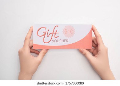 Top View Of Woman Holding Gift Voucher With 10 Dollars Sign On White Background