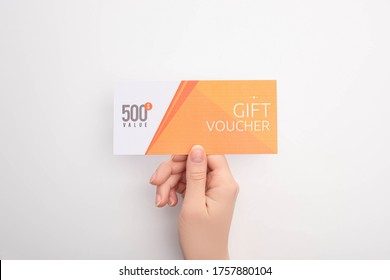 Top View Of Woman Holding Gift Voucher With 500 Value Lettering On White Background