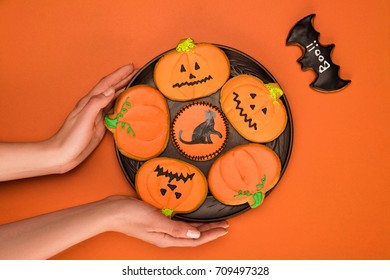 Top View Of Woman Holding Plate Of Homemade Halloween Cookies