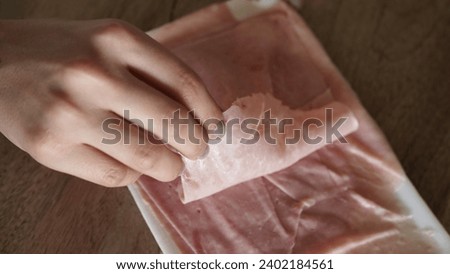 Top view of a woman holding a slice of ham