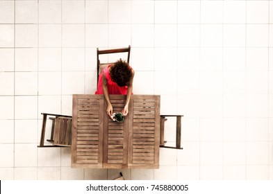 Top View Of Woman Holding Small Bonsai In Flowerpot On The Wooden Table. Girl Sitting Alone And Lonely On Wood Chair.