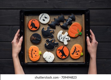 top view of woman holding tray of various halloween cookies - Powered by Shutterstock