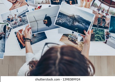 Top view of a woman photographer working in studio. Female photographer checking image prints. - Shutterstock ID 1398389924