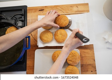 Top View Of A Woman Placing Freshly Baked Home Made Vegan Doughnuts On A Paper Towel.