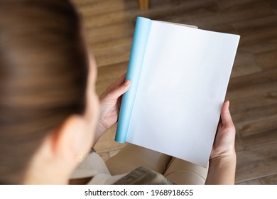 Top View Of A Woman Reading An Open Book Or Magazine. Empty Page. Mock Up