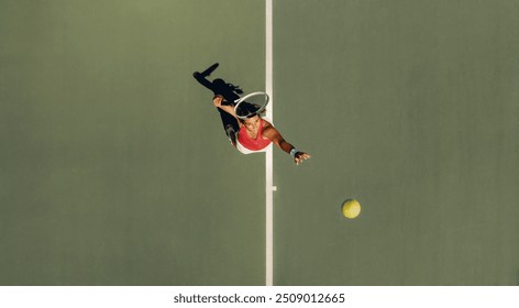 Top view of a woman serving during a tennis match, highlighting athleticism, precision, and the dynamic nature of sports. - Powered by Shutterstock