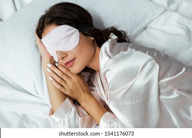 Top View Of Woman In Sleeping Mask Lying In Bed At Morning 