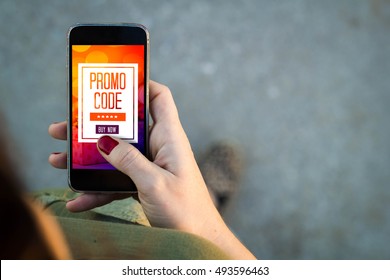 Top View Of Woman Walking In The Street Using Her Mobile Phone With Promo Code. All Screen Graphics Are Made Up.