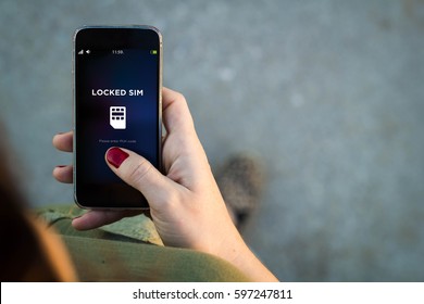 Top view of woman walking in the street using her mobile phone with copy space and locked sim. All screen graphics are made up. - Shutterstock ID 597247811