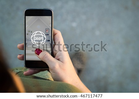 Top view of woman walking in the street surfing 360 degree view in her mobile. All screen graphics are made up.