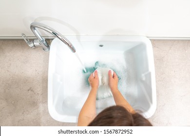 Top view of woman washing white clothes in laundry sink - Powered by Shutterstock