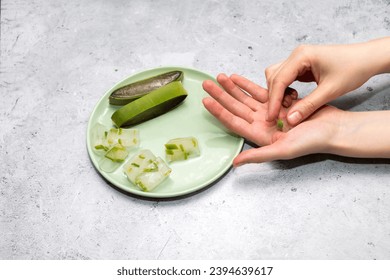 Top View Woman's Hand Holding Aloe Juice Ice Cubes, Aloe Vera Plant On Green Plate On Table. Flat Lay Horizontal plane. Natural Homemade Cosmetics, DIY Concept. Food, Medicine And Beauty Industry. - Shutterstock ID 2394639617