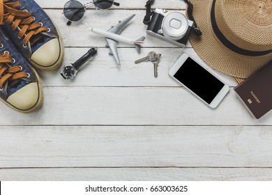 Top View Women Accessories To Travel Concept.White Mobile Phone,airplane,hat,passport,watch,sunglasses On Wood Table.