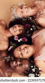 Top view, women diversity or faces with flowers on studio background in empowerment, divine feminine energy or self love. Smile, happy or skincare beauty models with plants, leaf or organic spa glow