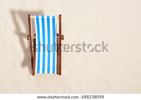 Top view of wooden beach chair on beach.