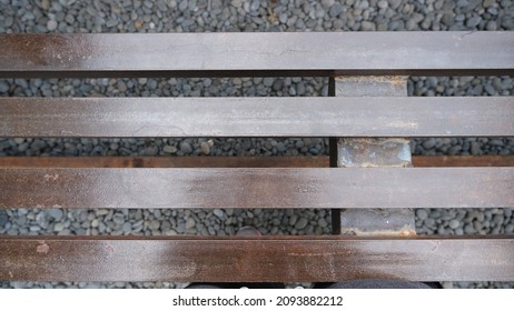 Top View Of A Wooden Bench With A Pebble Floor In The Background.  Selective Focus