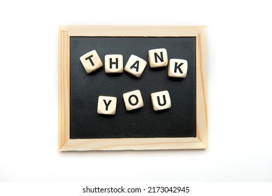 Top View Of Wooden Cubes With Thank You Inscription On Black Chalk Board.