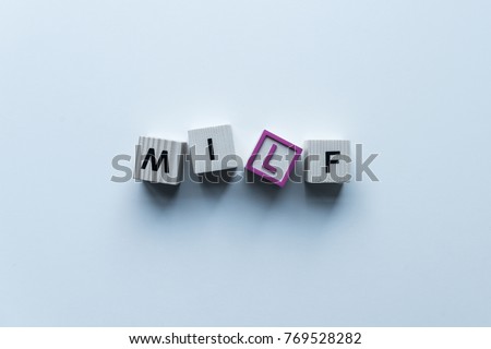 top view of wooden cubes with word Milf on blue tabletop