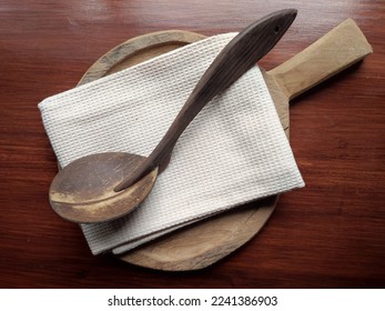 Top view of wooden kitchen utensils, coconut shell laddle, napkin and chopping board, environmental friendly