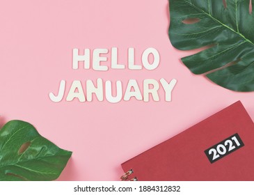 Top view of wooden letters HELLO JANUARY  with  red 2021 diary or planner and monstera leaves on pink background . greeting new month and new year. - Powered by Shutterstock
