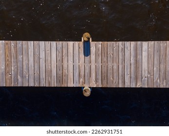 Top view of a wooden pier with two pillars on the side against the brown water surface- Navarre, FL. Horizontal wooden pier above the water. - Powered by Shutterstock