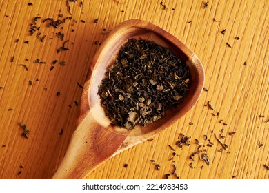 Top View Of Wooden Spoon With Dry Tea Leaves On The Wooden Table. Cozy Kitchen Background