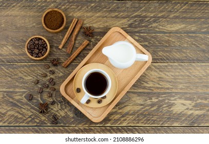 top view of the wooden tray with expresso cup, coffee assortment and milkman with milk. brown wood background - Powered by Shutterstock