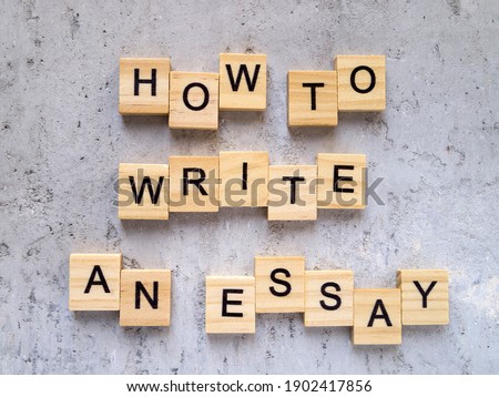 Top view of words HOW TO WRITE AN ESSAY made from wooden letters. The concept of writing skills.