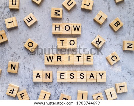 Top view of words HOW TO WRITE 
AN ESSAY made from wooden letters. The concept of writing skills.