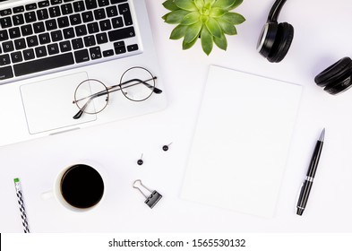 Top View Work Office Desk With Silver Aluminum Laptop, Blank Magazine Cover Mockup, Glasses And Coffee Cup