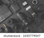 top view of work space photographer with digital camera, flash, cleaning kit, memory card, external harddisk, USB card reader, laptop and camera accessory on black table background