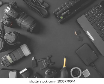 Top View Of Work Space Photographer With Digital Camera, Flash, Cleaning Kit, Memory Card, External Harddisk, USB Card Reader, Laptop And Camera Accessory On Black Table Background With Copyspace.