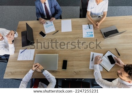 top view work workplace. A team of young office workers, businessmen with laptop working at the table, communicating together in an office. Corporate businessteam and manager in a meeting. coworking.