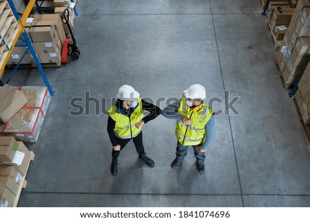 Top view workers with face mask greeting indoors in warehouse, coronavirus concept.