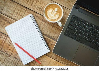 Top View Of Working Desk Have Laptop And Coffee Latte Art And Note Pad With Space. Office And Home Office Concept.