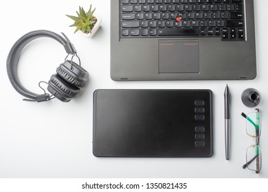 Top view of the workplace designer. Creative designer, graphics tablet, laptop, and accessories for the graphic designer.Flat lay.On a white background