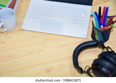 Top View Of A Workplace With Laptop Computer Pen Headphones Book And Cup With Blank Space On The Desktop And Online Learning Tools, Concept Remote Study And Work From A Home Education Background