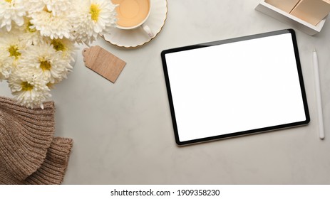Top view of workspace with digital tablet, tea cup, flower and supplies on marble table, clipping path - Shutterstock ID 1909358230