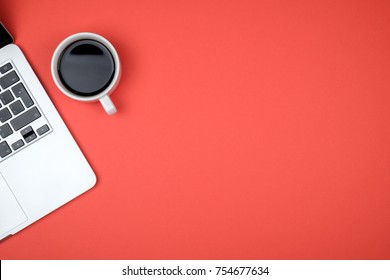 Top view of workspace with laptop, cup of coffee and copy space on colored background