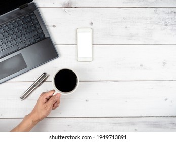 Top view workspace laptop glasses and two silver pen and hand hold coffee cup copy space