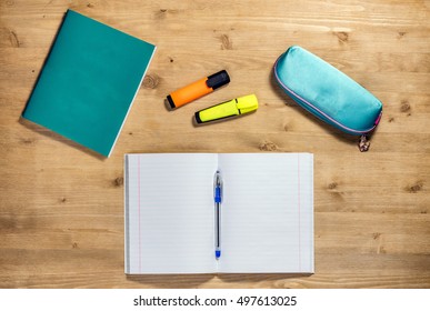 Top View Workspace Of The School Supplies Copybook, Case, Pen, Apple, Autumn Maple Leaf, Marker On Desk