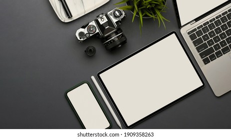 Top view of workspace with smartphone, tablet, laptop, camera and plant pot on the table, clipping path - Powered by Shutterstock