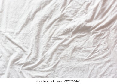 Top View Of Wrinkles On An Untidy White Bed Sheet In A Bedroom After A Long Night Sleep And Waking Up In The Morning. A Pattern Can Be Used For Making A Wavy Flag By Distort / Displacement Map Method.