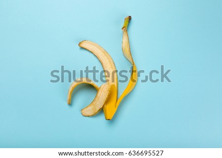 Top view of yellow banana peel isolated on blue, colorful background