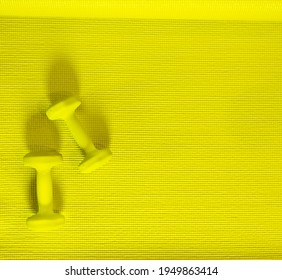 Top View, Yellow Dumbbells Flat Lay On Yoga Mat, Set Of Indoor Exercise Equipment. Lifestyle Workout At Home. Monochromatic Color Objects On Pattern Texture With Copy Space. Wellness, Healthy Concept