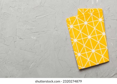 top view with yellow empty kitchen napkin isolated on table background. Folded cloth for mockup with copy space, Flat lay. Minimal style.